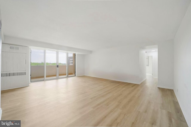 unfurnished living room with baseboards, light wood-style flooring, and visible vents