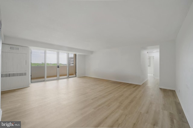 unfurnished living room featuring baseboards, light wood finished floors, and visible vents