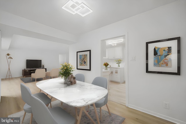 dining room featuring baseboards, light wood-style flooring, and visible vents