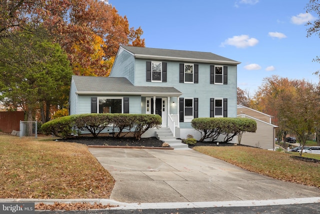 colonial inspired home with a porch and a front lawn