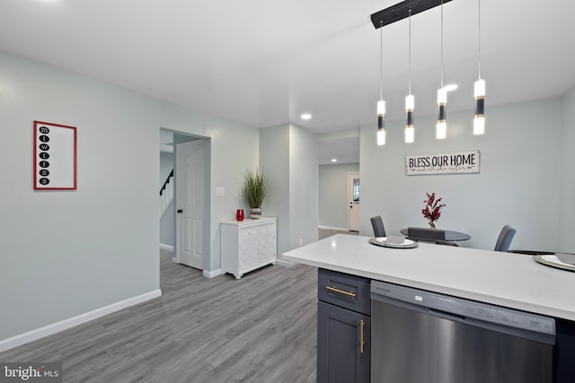 kitchen featuring dishwasher, hanging light fixtures, gray cabinets, and light hardwood / wood-style flooring