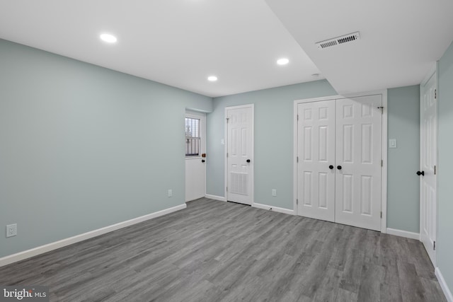 unfurnished bedroom featuring multiple closets and light hardwood / wood-style flooring