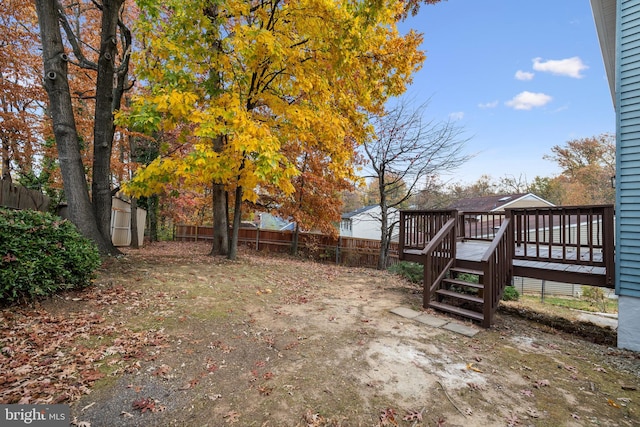 view of yard featuring a storage shed and a wooden deck