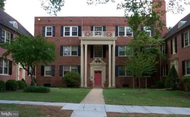 view of front of house with a front yard and a balcony