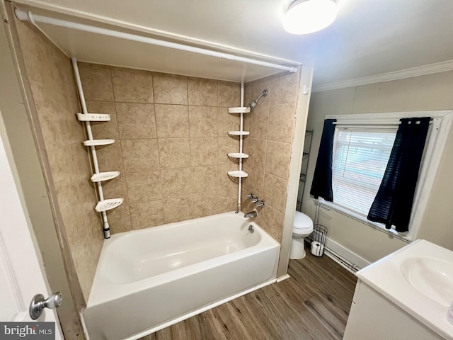 full bathroom featuring tiled shower / bath combo, crown molding, hardwood / wood-style floors, toilet, and vanity