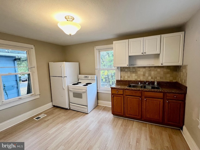 kitchen featuring sink, tasteful backsplash, light hardwood / wood-style flooring, a textured ceiling, and white appliances