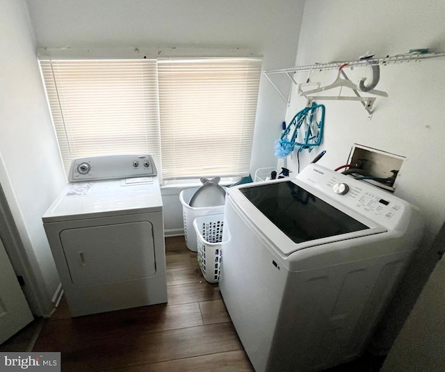 laundry area with independent washer and dryer and dark wood-type flooring