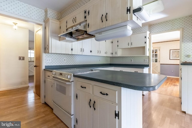 kitchen featuring white cabinets, tasteful backsplash, a kitchen breakfast bar, light wood-type flooring, and white range with electric stovetop