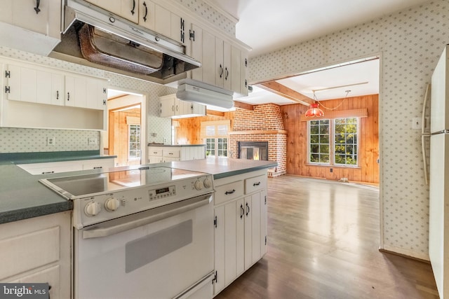 kitchen featuring a brick fireplace, dark hardwood / wood-style flooring, white cabinets, and white appliances