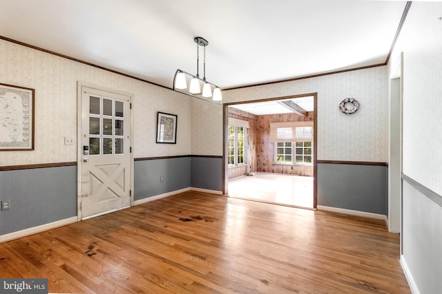 unfurnished dining area with a skylight, hardwood / wood-style flooring, and crown molding