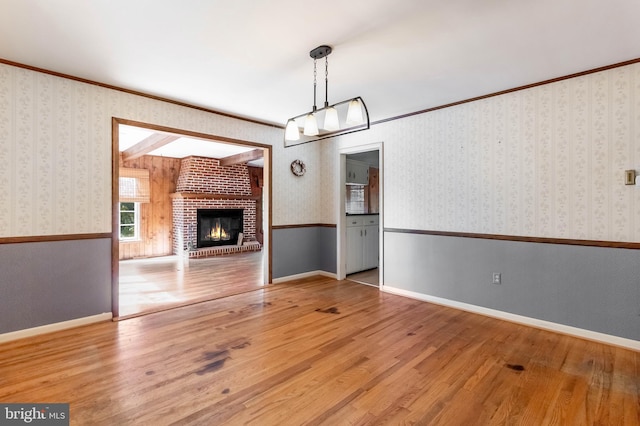 unfurnished living room with ornamental molding, a fireplace, and hardwood / wood-style flooring