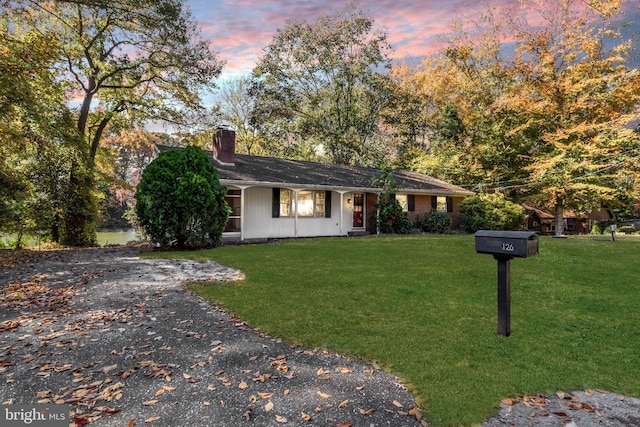 ranch-style home with a lawn