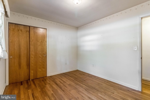 unfurnished bedroom with a closet and hardwood / wood-style floors