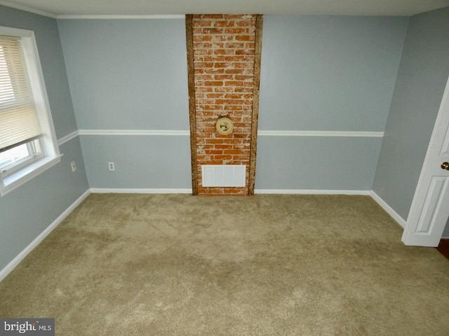 carpeted empty room featuring crown molding