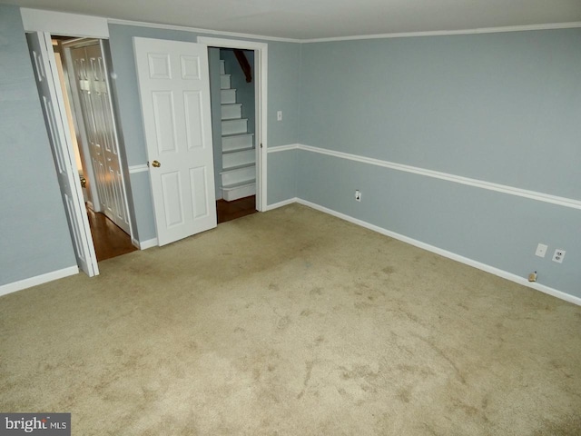 unfurnished bedroom with ornamental molding and carpet floors