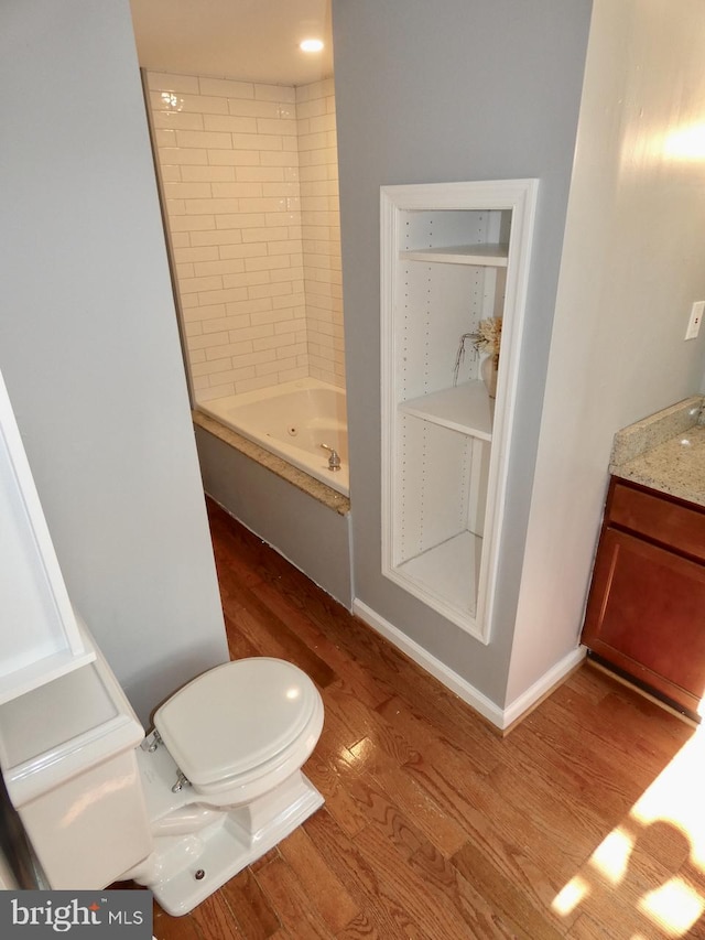 full bathroom with vanity, toilet, tiled shower / bath combo, and hardwood / wood-style floors