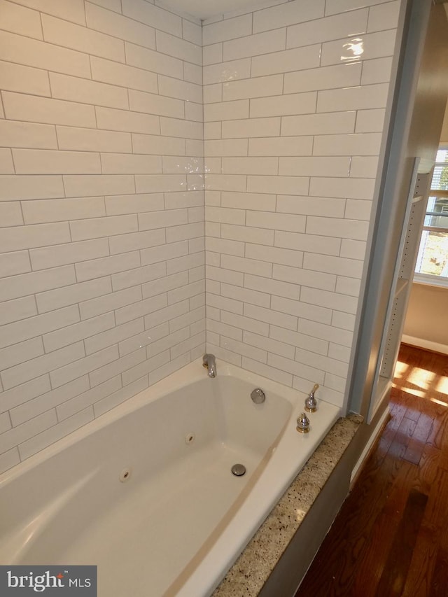 bathroom with tiled shower / bath and hardwood / wood-style floors