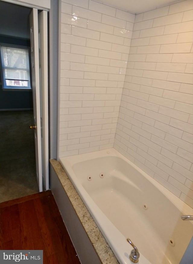 bathroom featuring tiled shower / bath and wood-type flooring