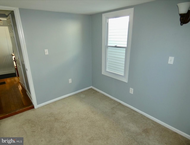 unfurnished room featuring light carpet