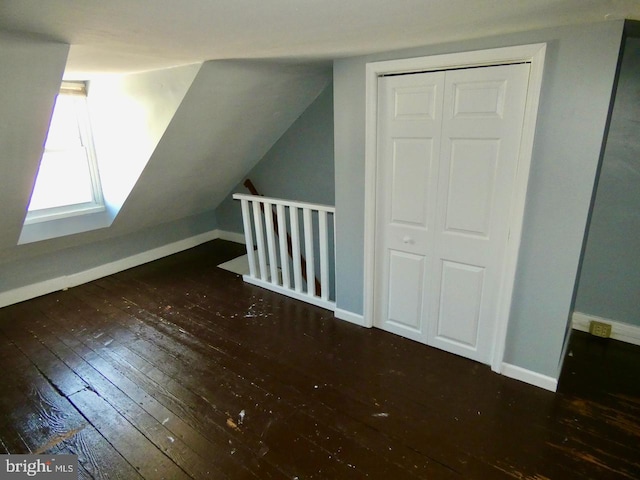 additional living space with vaulted ceiling and dark hardwood / wood-style floors