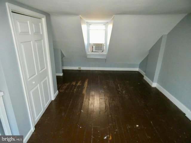 additional living space with cooling unit and dark hardwood / wood-style flooring