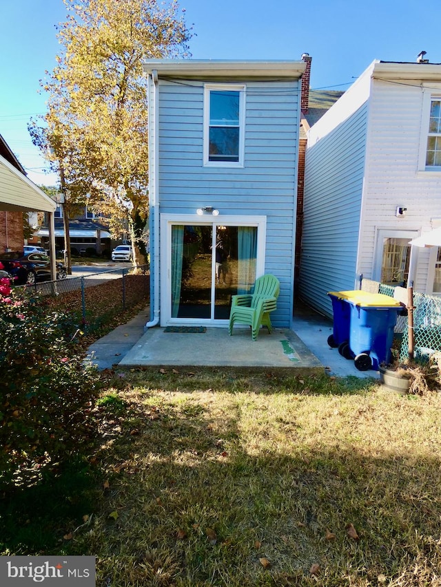 rear view of house featuring a patio and a lawn