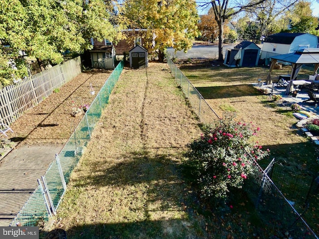 view of yard featuring a gazebo, a shed, and a patio