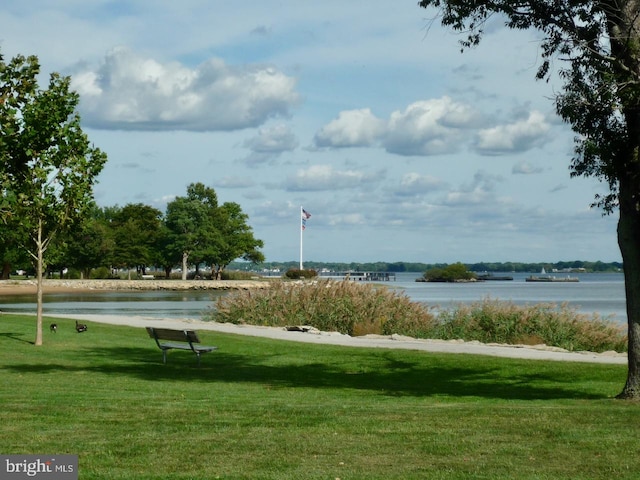 surrounding community with a water view and a yard