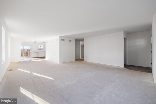 unfurnished living room featuring a notable chandelier