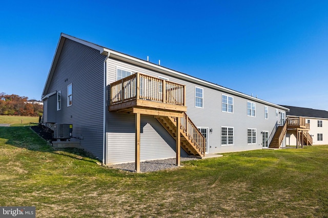 rear view of property featuring central AC, a deck, and a lawn