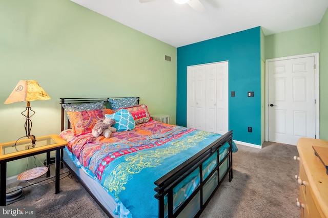 bedroom featuring dark colored carpet, ceiling fan, and a closet