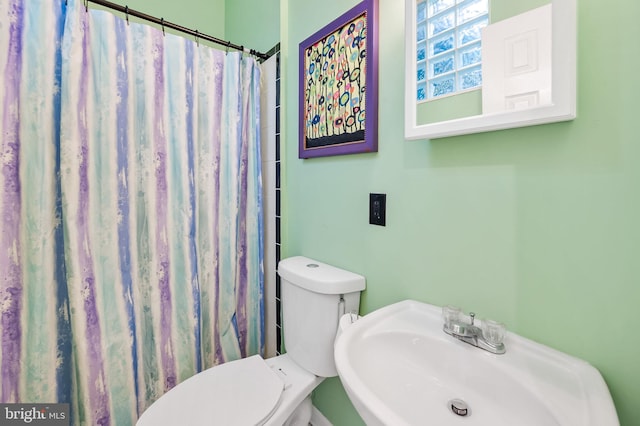 bathroom with a shower with curtain, sink, and toilet