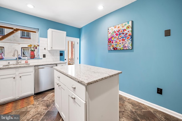 kitchen featuring dishwasher, a center island, white cabinetry, and sink