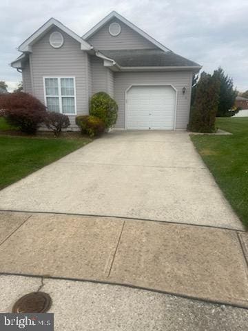 view of front of home with a front yard and a garage