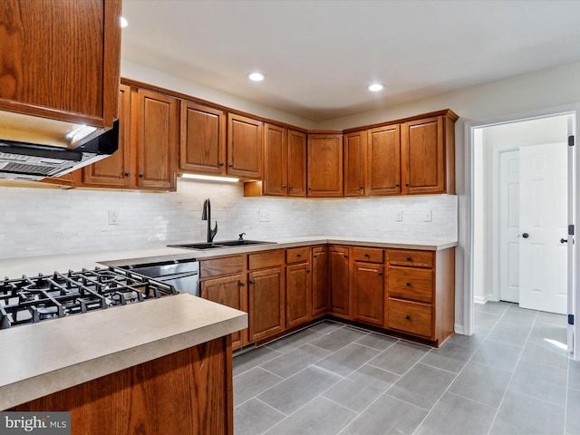 kitchen featuring backsplash, light tile patterned flooring, sink, and stainless steel dishwasher