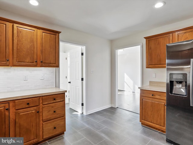 kitchen with stainless steel refrigerator with ice dispenser and tasteful backsplash