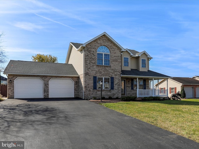 view of front of home with a front yard, a garage, and a porch