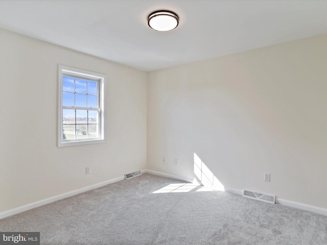 spare room featuring light colored carpet