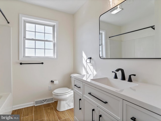 full bathroom with toilet, hardwood / wood-style flooring, vanity, and washtub / shower combination