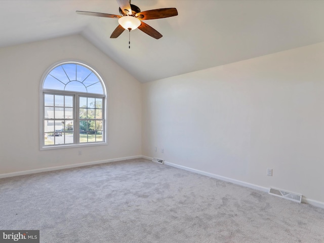 carpeted spare room featuring ceiling fan and vaulted ceiling