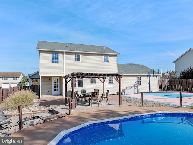 back of property with a pergola, a patio area, and a fenced in pool