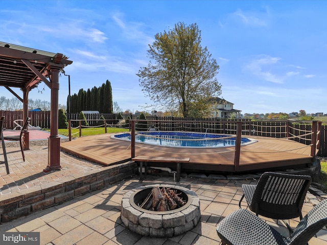 view of patio / terrace featuring an outdoor fire pit and a swimming pool side deck