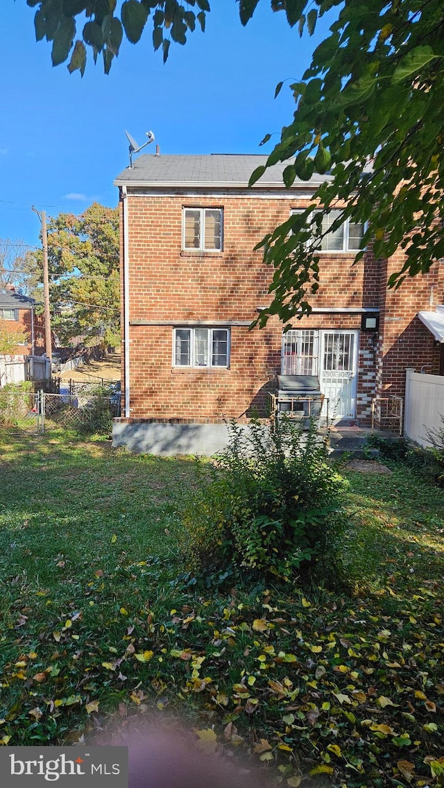 rear view of property featuring a patio and a lawn