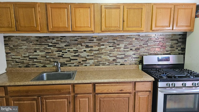 kitchen with sink, stainless steel gas stove, and decorative backsplash