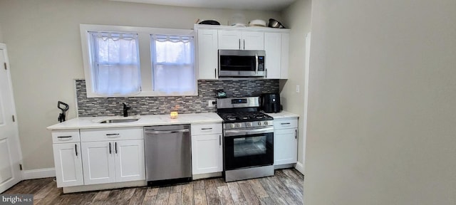 kitchen with white cabinets, stainless steel appliances, and wood-type flooring