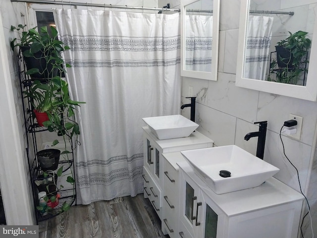 bathroom featuring vanity, hardwood / wood-style floors, walk in shower, and tile walls