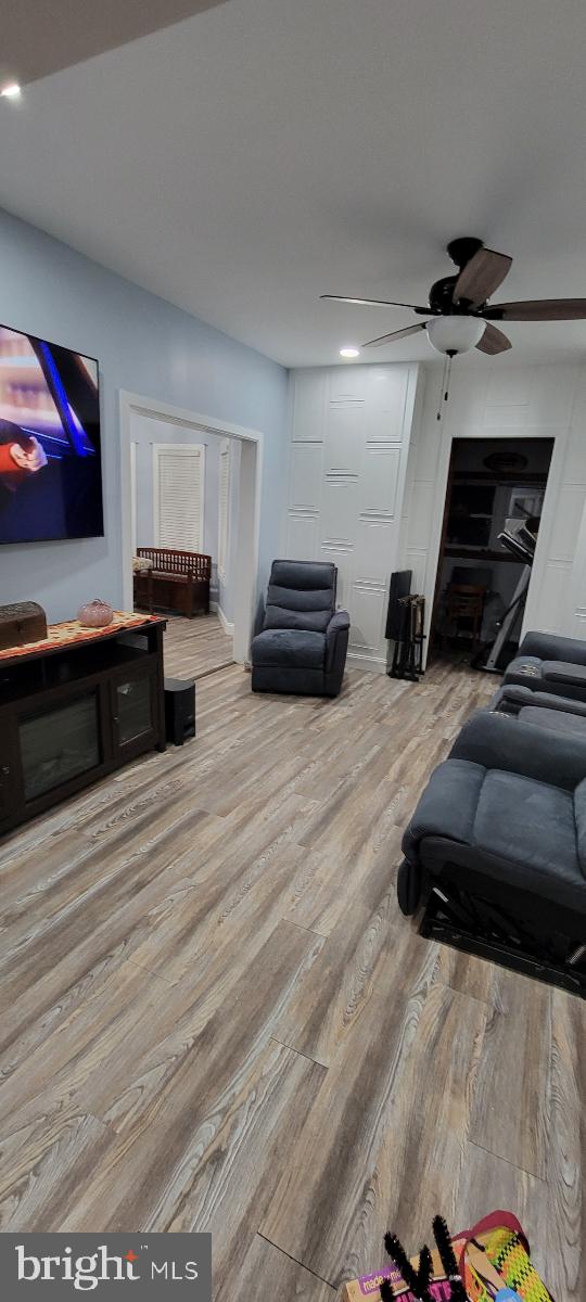 living room with light hardwood / wood-style flooring and ceiling fan