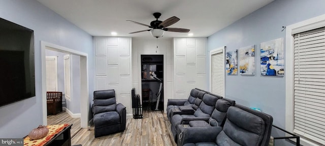 living room with light wood-type flooring and ceiling fan