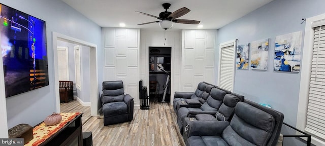 living room with light hardwood / wood-style floors and ceiling fan