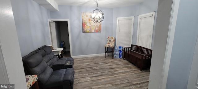 sitting room with hardwood / wood-style flooring and an inviting chandelier